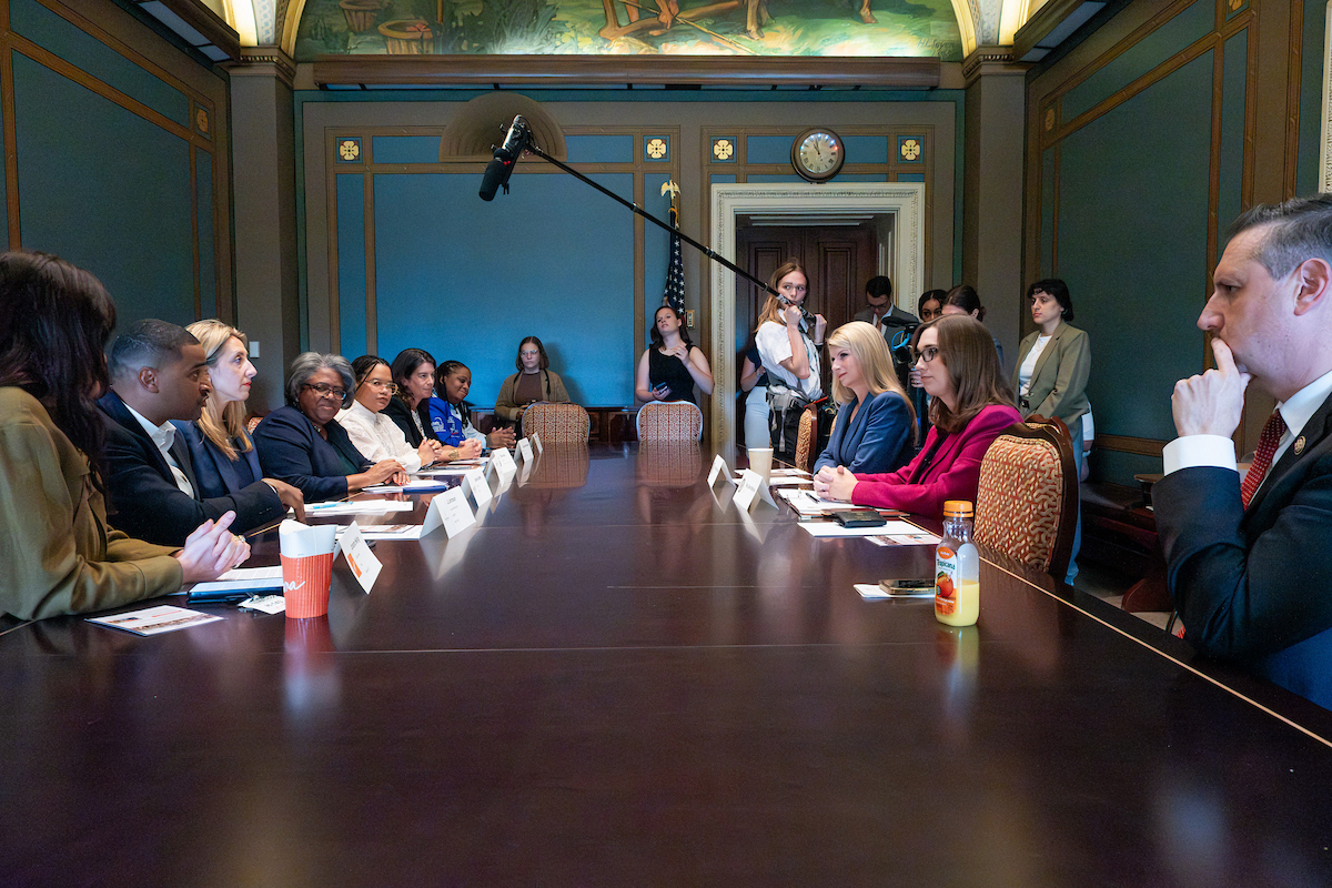 Chefs, advocates, and Congressional members meet around a table to discuss paid leave.